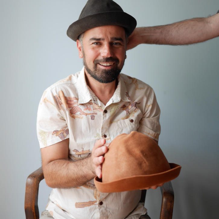 mister vertigo teatro sobrero en mano y otro sombrero que alguien se lo coloca en la cabeza color